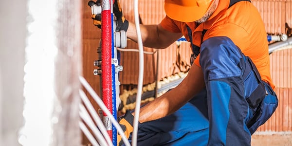 subcontractor wearing orange and working with wires
